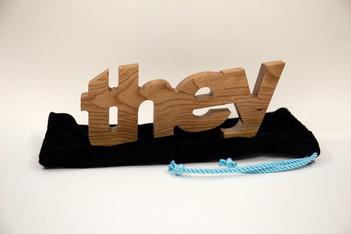 ​Sculpture en bois du pronom ''They''